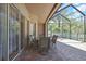 Covered patio with brick pavers, outdoor dining table, and screen enclosure with views of the backyard at 3033 Marble Crest Dr, Land O Lakes, FL 34638