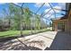 Screened in patio with brick pavers overlooking a lush green yard with mature trees at 3033 Marble Crest Dr, Land O Lakes, FL 34638