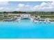 Aerial view of the clear lagoon with beach club featuring chairs and relaxing cabana areas at 30903 Quail Caper Cir, San Antonio, FL 33576