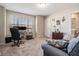 Well-lit bedroom with a work station, neutral carpet, and a comfortable seating area at 30903 Quail Caper Cir, San Antonio, FL 33576