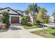 Inviting townhome showcasing a beautifully landscaped front yard and two-car garage at 30903 Quail Caper Cir, San Antonio, FL 33576