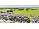 Aerial view of townhomes with green lawns and a large greenfield in the background at 30903 Quail Caper Cir, San Antonio, FL 33576