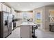 Bright kitchen features white cabinets, stainless steel appliances, and an island with bar seating at 30903 Quail Caper Cir, San Antonio, FL 33576