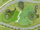 A top-down aerial view of a unique community park area with water features, green spaces, and lush greenery at 31616 Parkland Bay Way, San Antonio, FL 33576
