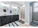 Modern bathroom with dual sinks, a walk-in shower, and shiplap accent wall at 31616 Parkland Bay Way, San Antonio, FL 33576