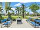 Outdoor firepit area with comfortable blue seating, set amidst a lush green landscape with palm trees at 31616 Parkland Bay Way, San Antonio, FL 33576