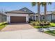 Charming single Gathering home featuring a brick driveway, well manicured lawn and mature palm trees at 31616 Parkland Bay Way, San Antonio, FL 33576