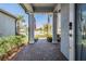 Inviting covered front porch with brick paving and view of the neighborhood street at 31616 Parkland Bay Way, San Antonio, FL 33576