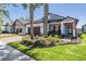 Charming single-Gathering home featuring a landscaped front yard and a welcoming front porch with rocking chairs at 31616 Parkland Bay Way, San Antonio, FL 33576