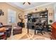Well-lit home office with a large desk, built-in shelving, and comfortable seating at 31616 Parkland Bay Way, San Antonio, FL 33576