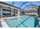 Inviting screened-in pool area with a covered patio, lounge chairs, and a beautiful blue pool at 31616 Parkland Bay Way, San Antonio, FL 33576