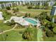 Overhead view of the community pool, shuffleboard courts, and manicured green spaces at 4210 Ironwood Cir # 501J, Bradenton, FL 34209
