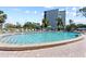 Well maintained outdoor pool with lounge seating and a lush green lawn, with building in background at 4210 Ironwood Cir # 501J, Bradenton, FL 34209