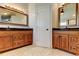 Bathroom featuring double vanities with granite countertops and framed mirrors at 4702 Corsage Dr, Lutz, FL 33558
