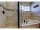 Bathroom with a glass-enclosed shower and soaking tub with marble surround at 4702 Corsage Dr, Lutz, FL 33558