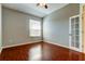 Bedroom featuring laminate flooring, gray walls, a window and a door with glass panels at 4702 Corsage Dr, Lutz, FL 33558