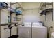 Well-organized laundry room with washer, dryer, and ample shelving for storage and convenience at 4702 Corsage Dr, Lutz, FL 33558