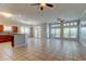 Open-concept living area with tile flooring, large windows, and an adjoining kitchen at 4702 Corsage Dr, Lutz, FL 33558