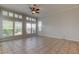Bright living room with large windows, shutters, and a ceiling fan at 4702 Corsage Dr, Lutz, FL 33558