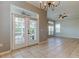 Living room featuring tile floors, a chandelier, and glass patio doors offering backyard views at 4702 Corsage Dr, Lutz, FL 33558