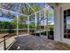 View of the brick paver screened patio with black metal fencing and landscaping at 4702 Corsage Dr, Lutz, FL 33558