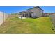 Large backyard with lush lawn, fenced perimeter, patio, and screened-in porch at 4923 Eagle Rock Dr, Wimauma, FL 33598