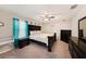 Bedroom with a dark wood bed, accent furniture, a ceiling fan, and soft, neutral walls at 4923 Eagle Rock Dr, Wimauma, FL 33598
