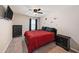 Cozy bedroom with a queen bed, dark furniture, ceiling fan and a red comforter at 4923 Eagle Rock Dr, Wimauma, FL 33598