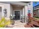 Covered front entry featuring updated landscaping, potted plants, and a secure doorway at 4923 Eagle Rock Dr, Wimauma, FL 33598