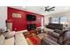 Cozy living room featuring a red accent wall, fireplace, and comfortable seating at 4923 Eagle Rock Dr, Wimauma, FL 33598