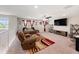 Spacious living room featuring plush seating, a ceiling fan, and a large flat-screen television at 4923 Eagle Rock Dr, Wimauma, FL 33598
