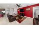 Stylish living room with a ceiling fan, tile flooring, and a red accent wall at 4923 Eagle Rock Dr, Wimauma, FL 33598