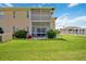 Back of house with screened patio and well maintained lawn, lush landscaping at 5800 Sabal Trace Dr # 301, North Port, FL 34287