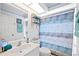 Well-lit bathroom featuring a single vanity and a shower with a decorative curtain at 5800 Sabal Trace Dr # 301, North Port, FL 34287
