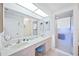 Bright bathroom with double vanity, large mirror, and glass-enclosed shower at 5800 Sabal Trace Dr # 301, North Port, FL 34287