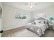 Bright bedroom with light-colored walls, light-colored wood floor, with a fan and two windows for plenty of light at 7310 Donna Dr, New Port Richey, FL 34652