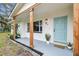 Inviting front porch with a welcoming blue door, wooden support beams, and stylish plants that enhance the home's curb appeal at 7310 Donna Dr, New Port Richey, FL 34652