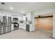 Bright kitchen with stainless steel appliances, white cabinets, and an open layout, creating a seamless transition to the living area at 7310 Donna Dr, New Port Richey, FL 34652
