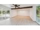 Large living room with a beamed ceiling, light-colored walls, and wood floor at 7310 Donna Dr, New Port Richey, FL 34652
