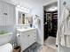 Bathroom with a sink vanity with white cabinets and a view into the walk-in closet at 7665 Sun Island S Dr # 401, South Pasadena, FL 33707