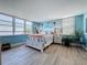 Bright bedroom with a large window offering water views, light wood-look flooring, and light blue walls at 7665 Sun Island S Dr # 401, South Pasadena, FL 33707