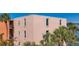 Exterior of building with balconies that overlook the bay with palm trees nearby at 7665 Sun Island S Dr # 401, South Pasadena, FL 33707