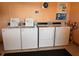 A laundry room with four white washers and dryers, informational posters, and space for residents at 7665 Sun Island S Dr # 401, South Pasadena, FL 33707