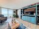 Living room with wood accent wall, entertainment center and sliding glass doors to a balcony at 7665 Sun Island S Dr # 401, South Pasadena, FL 33707
