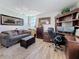 Comfortable home office with a gray couch, desk with dual monitors, and a large bookshelf at 7665 Sun Island S Dr # 401, South Pasadena, FL 33707