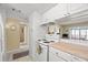 Clean kitchen featuring white cabinets and appliances, and an open layout to the living area at 7701 Starkey Rd # 526, Seminole, FL 33777