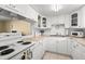 Cozy kitchen featuring white cabinets, a range, and an open view to the living room at 7701 Starkey Rd # 526, Seminole, FL 33777