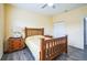 Comfortable bedroom with wooden bed frame, ceiling fan, and gray wood-look flooring at 7735 Wauchula Rd, Myakka City, FL 34251