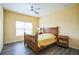 Bedroom with light yellow walls, wood-look flooring, and a wooden bed frame and window at 7735 Wauchula Rd, Myakka City, FL 34251