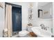 Modern bathroom with blue-tiled shower, white vanity and wainscoting at 774 29Th N Ave, St Petersburg, FL 33704